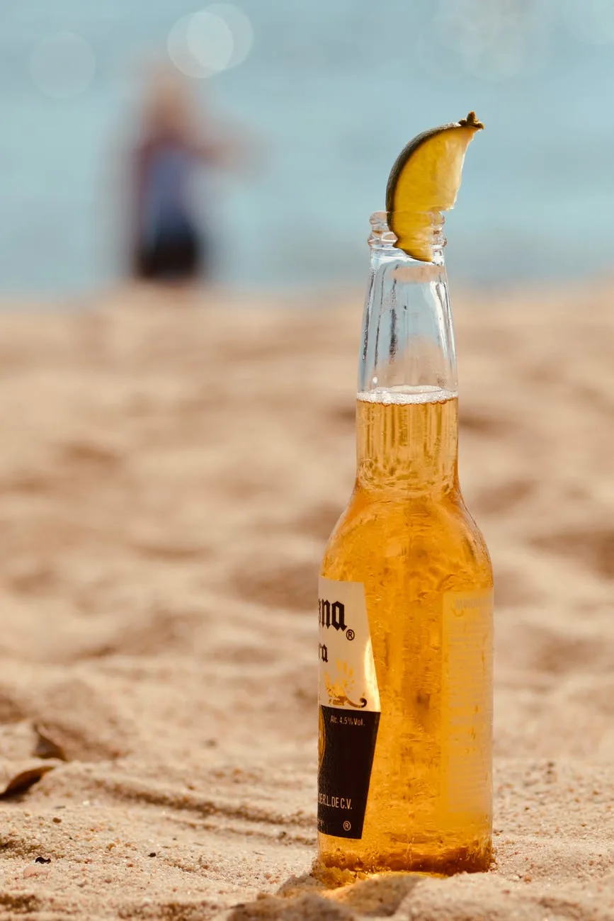 corona beer bottle across sands