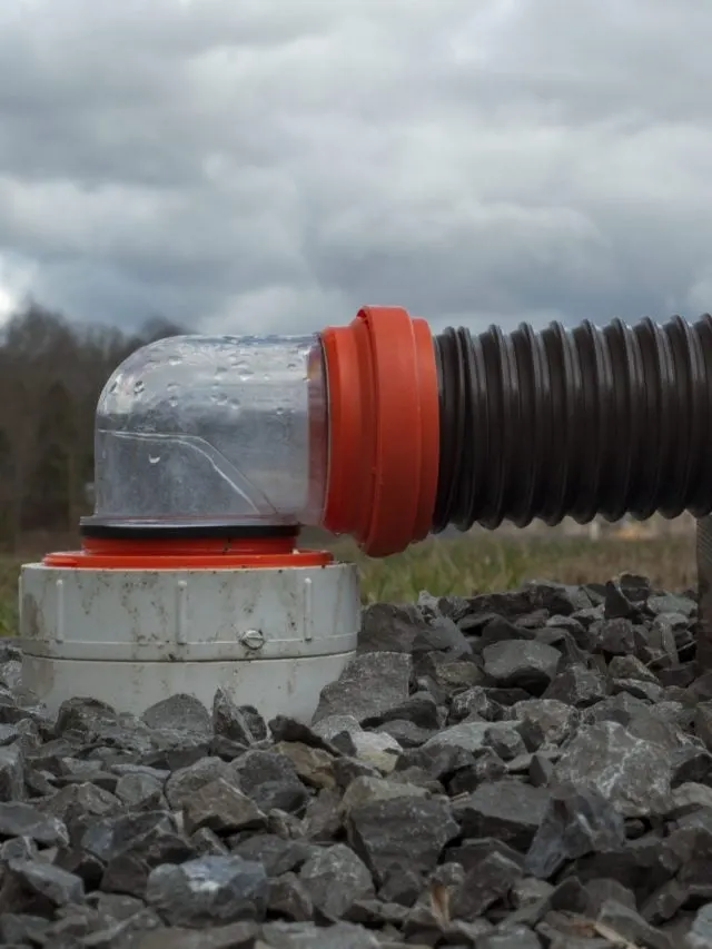 RV sewer hose connected to dump station with 90 degree clear fitting