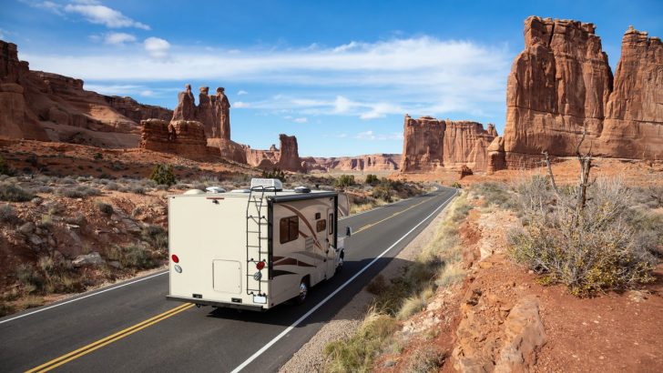 Camper riding on a Scenic road in the red rock canyons during a vibrant sunny day. Taken in Arches National Park, located near Moab, Utah, United States.