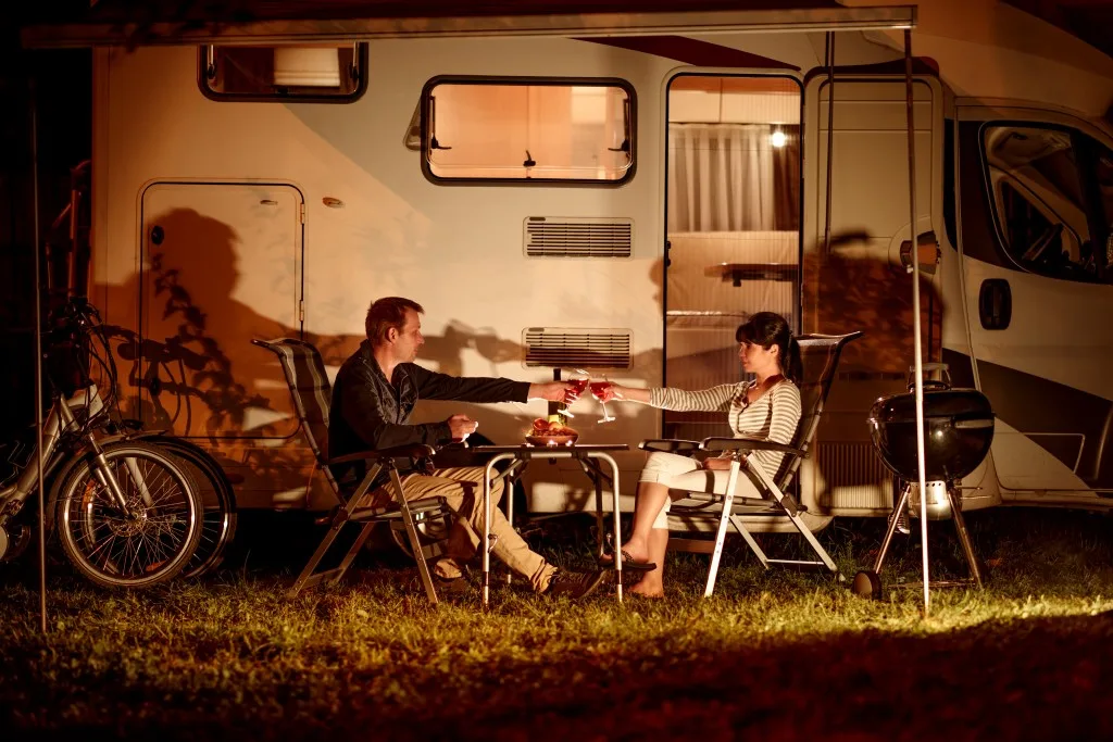 Couple drinking in front of their RV.