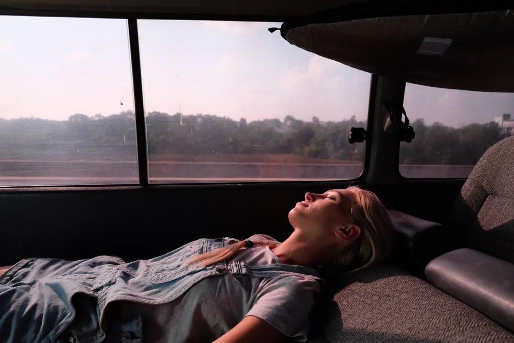 Woman sleeping in RV on roadtrip.