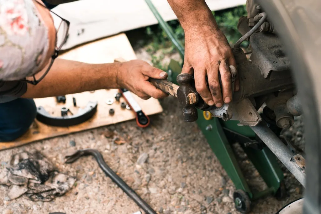 Auto mechanic repairing the brake system of car.