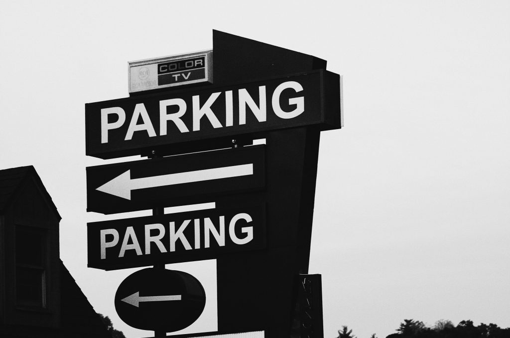 Black and white parking arrow sign.