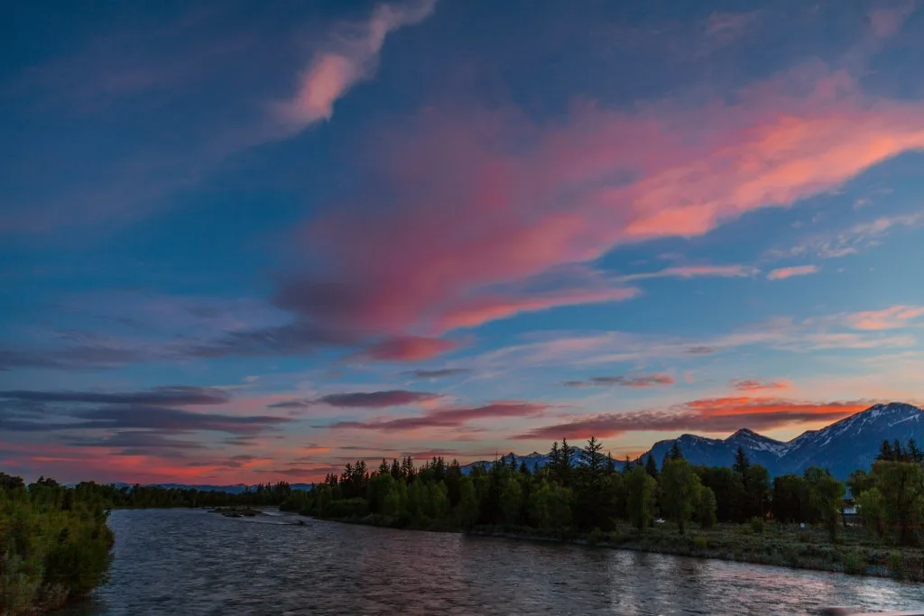 Sunset with pink and orange sky over scenic view of Jackson Hole.