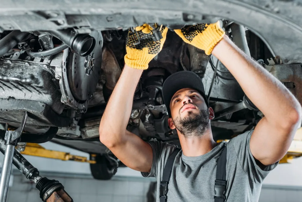 Male mechanic repairing a car in auto repair shop