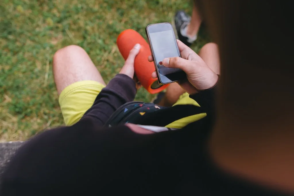 Man listening to music on portable speaker.