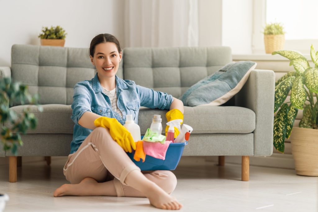 Woman sitting with a basket of cleaning products