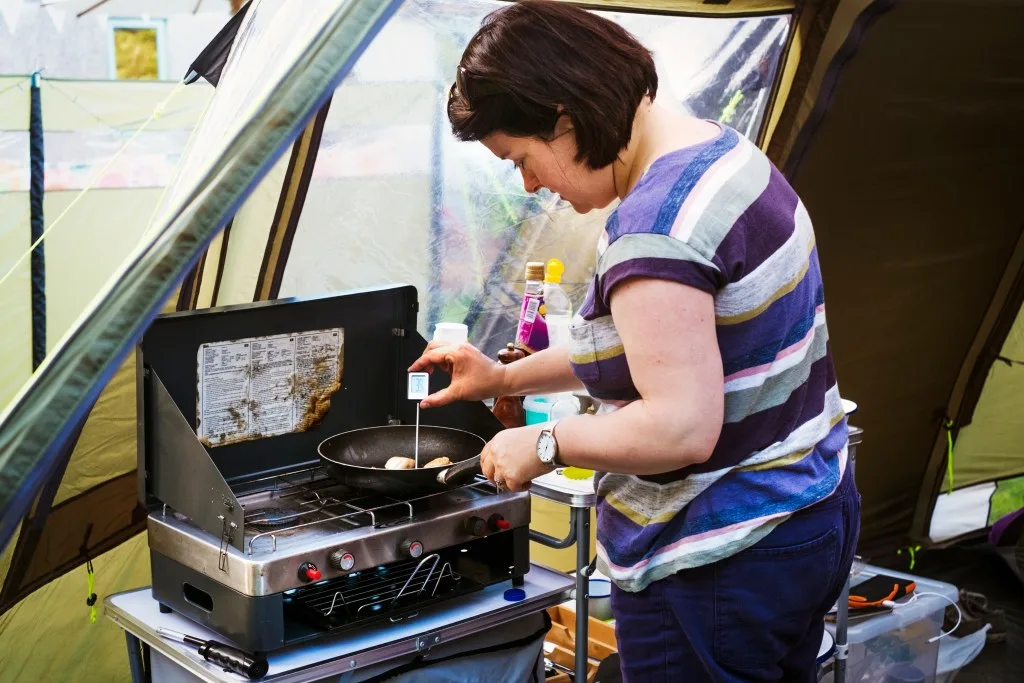 Woman cooking on camping stove.