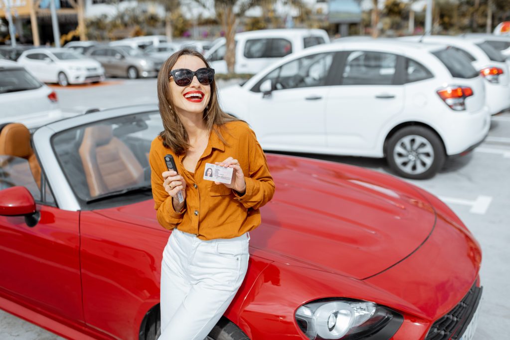 Woman standing with red car.