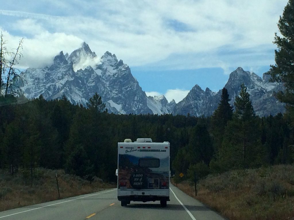 RV driving towards snowy mountains