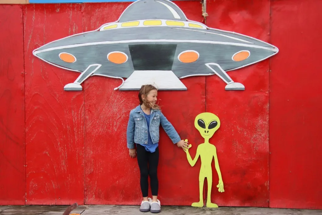 Little girl posing with pained alien.