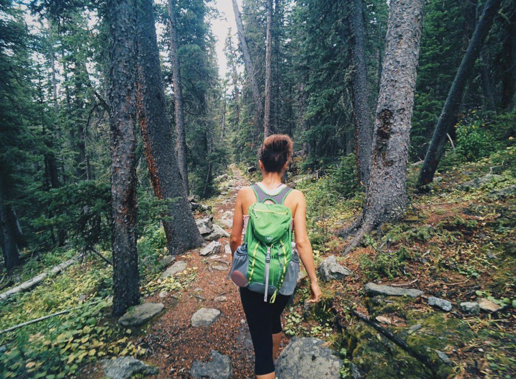Woman hiking through a forest.