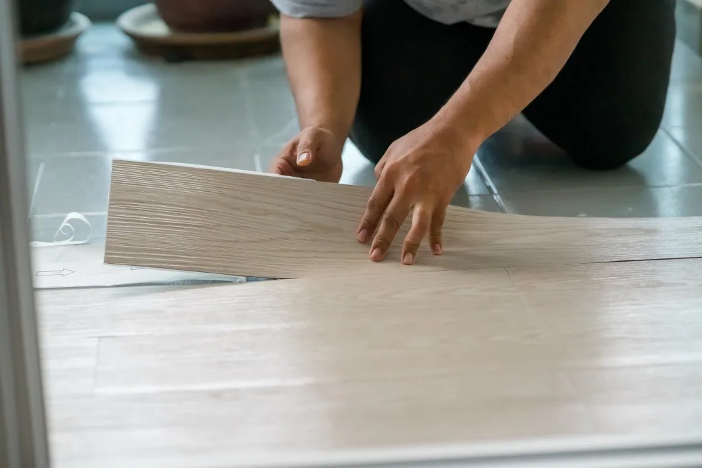Woman installing peel-and-stick flooring
