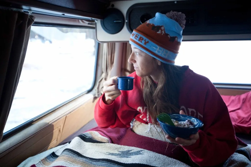 Woman in RV bed during winter.