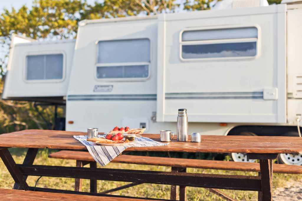 RV parked next to picnic table.