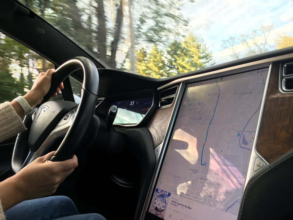 Woman using Tesla built in map while driving.