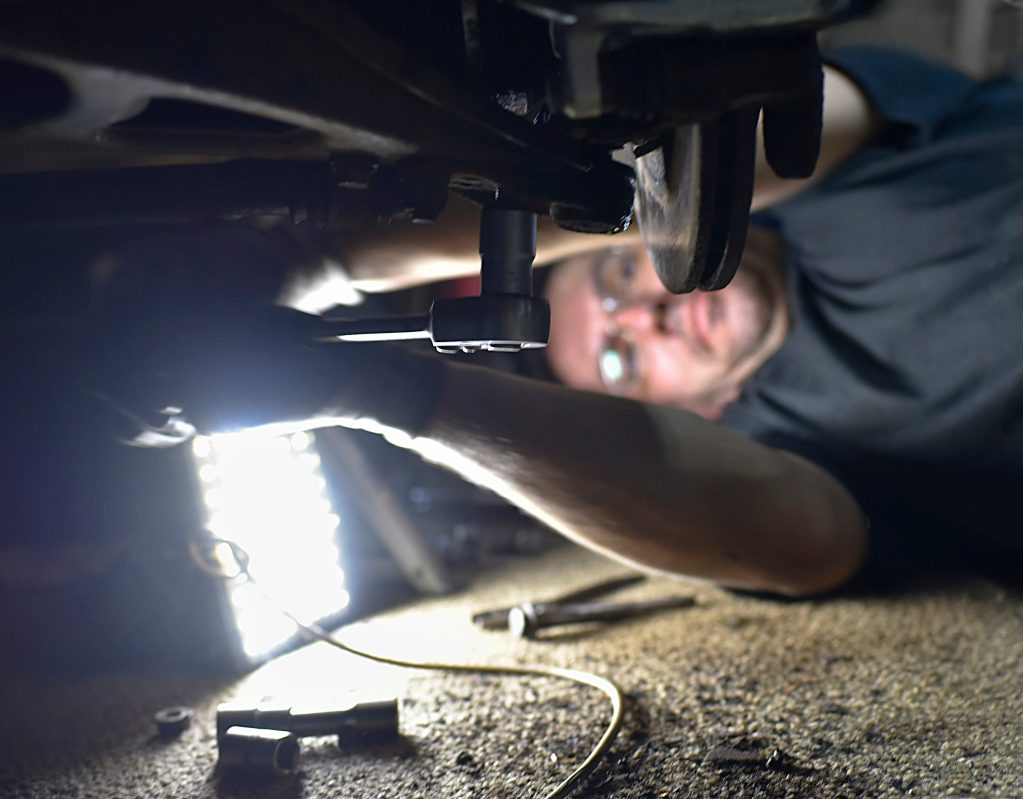 Male mechanic fixing axle.