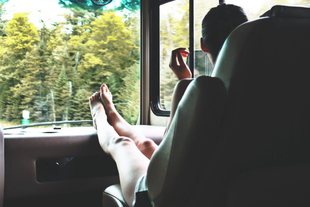 Woman sitting in RV with feet up relaxing.