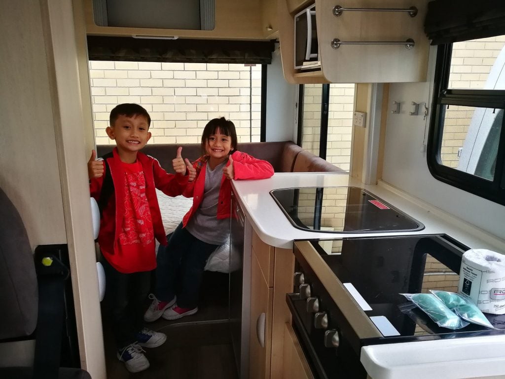 Two children happy in RV kitchen