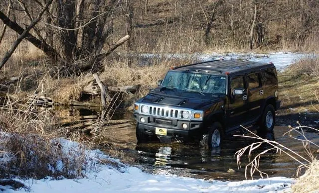 Hummer H2 driving through creek.