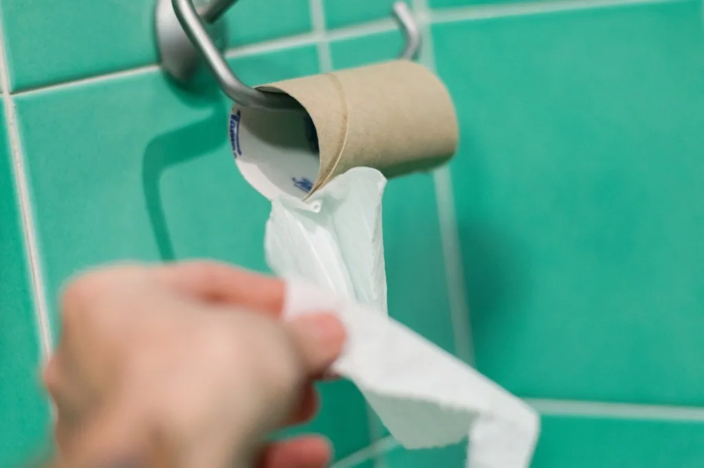 Pulling off the last bit of toilet paper.