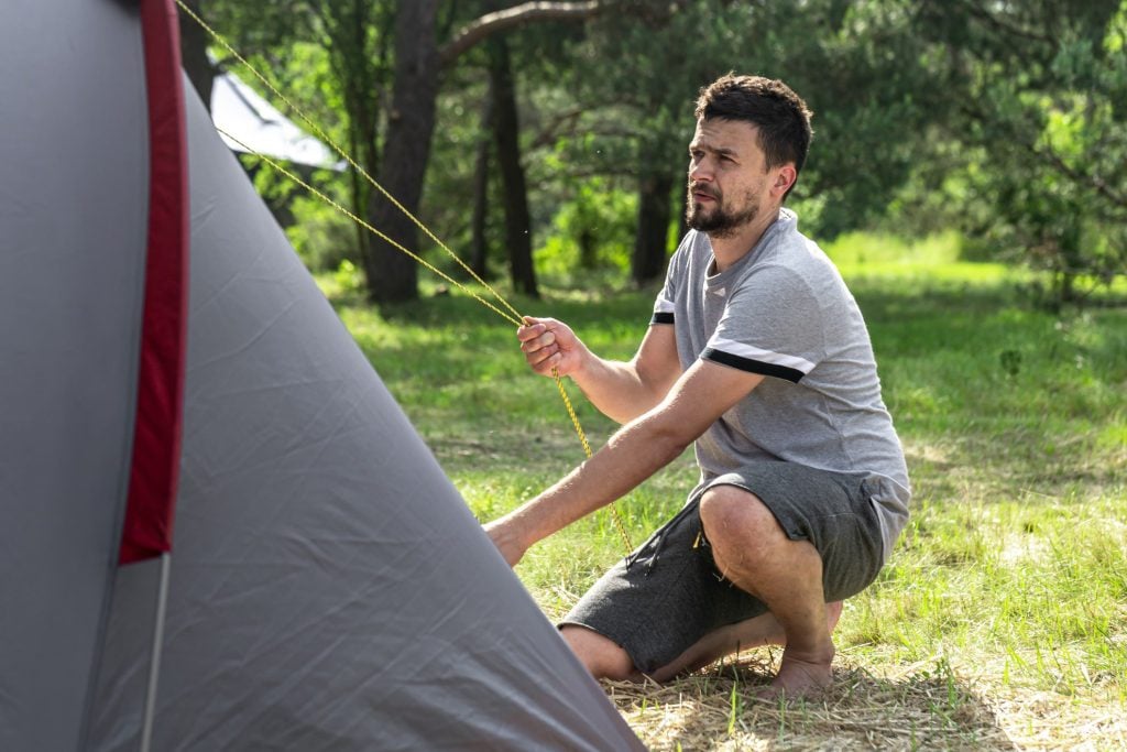 Man setting up tent.