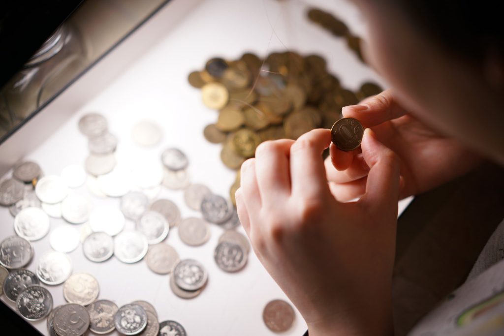 Person looking at gold and silver coins.