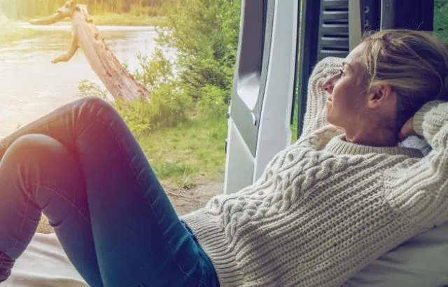 Young woman having a stunning view out of the back of her Camping Van