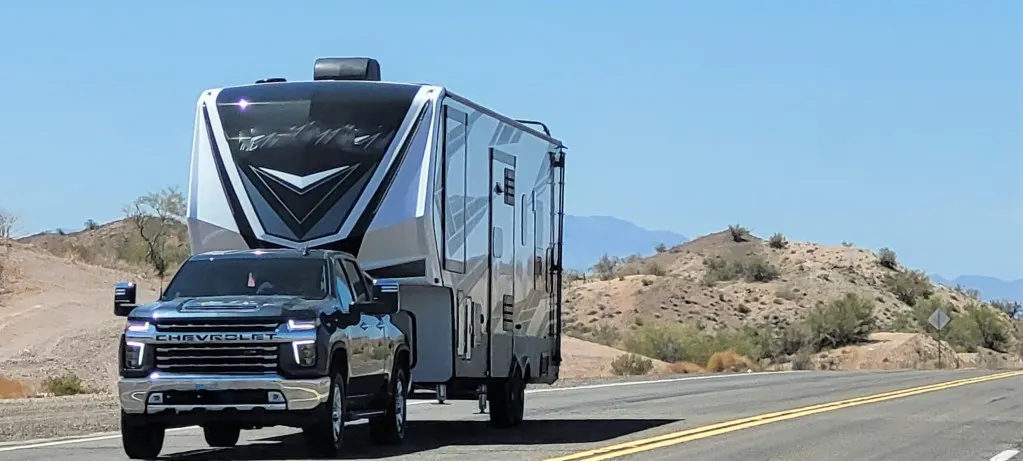 Truck towing fifth wheel RV.