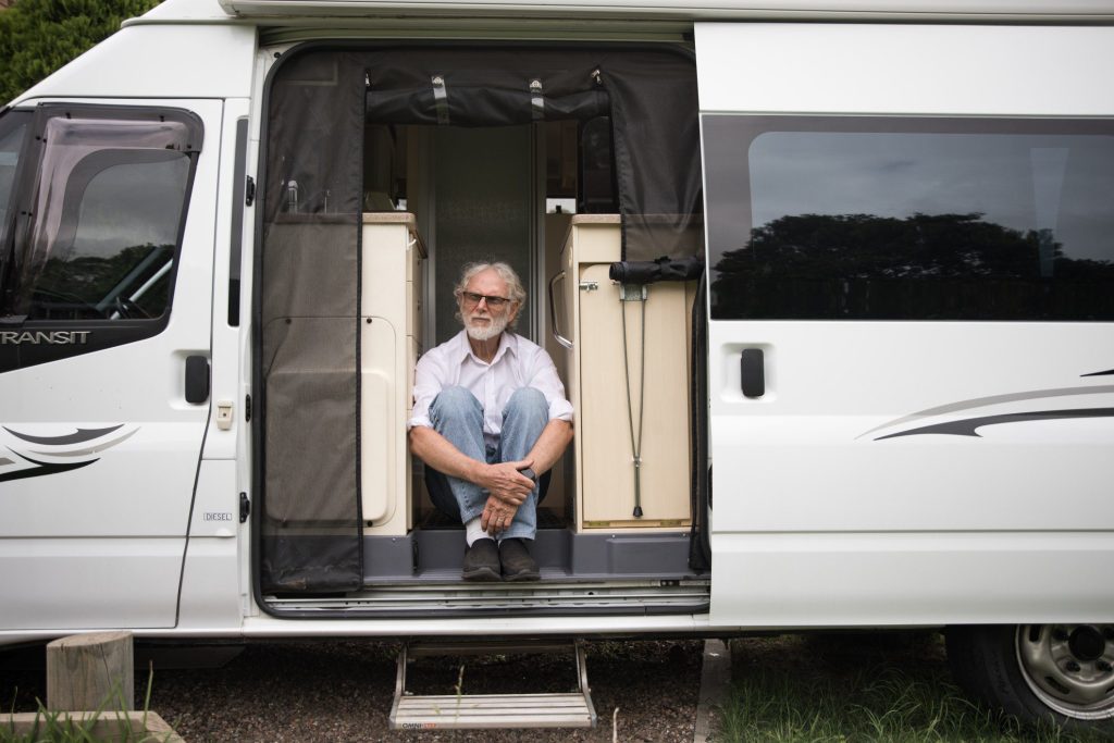 Old man sitting in van.