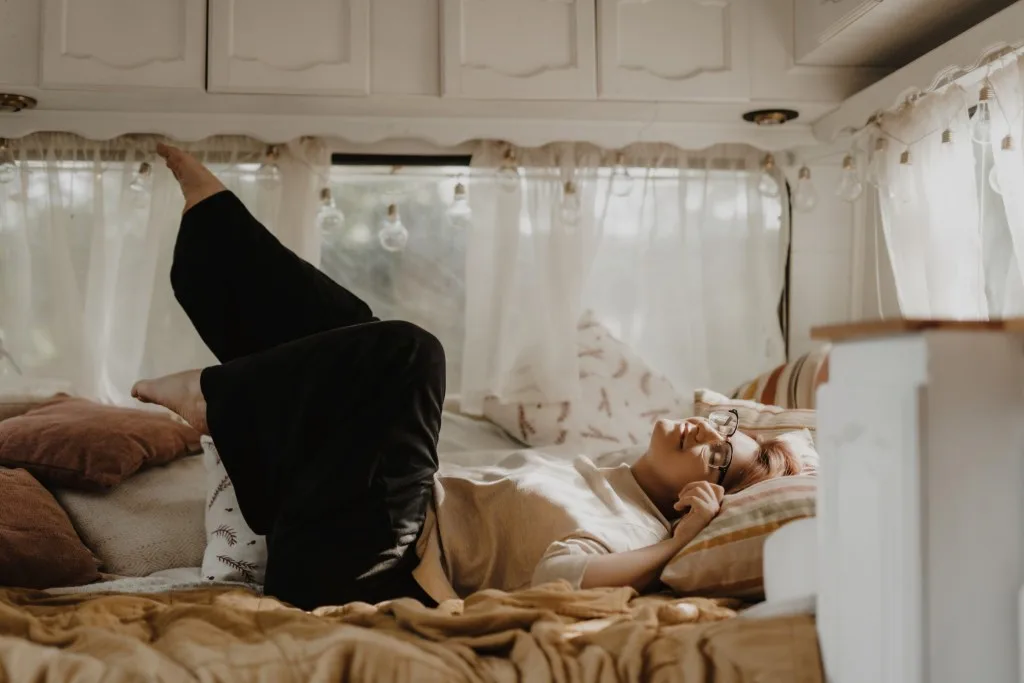 Woman laying in RV bed.