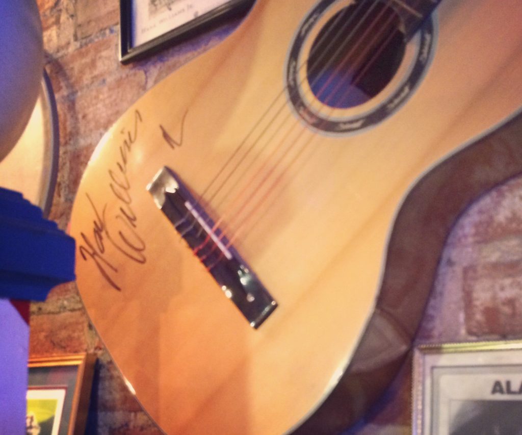 Hank Williams signed guitar in bar.
