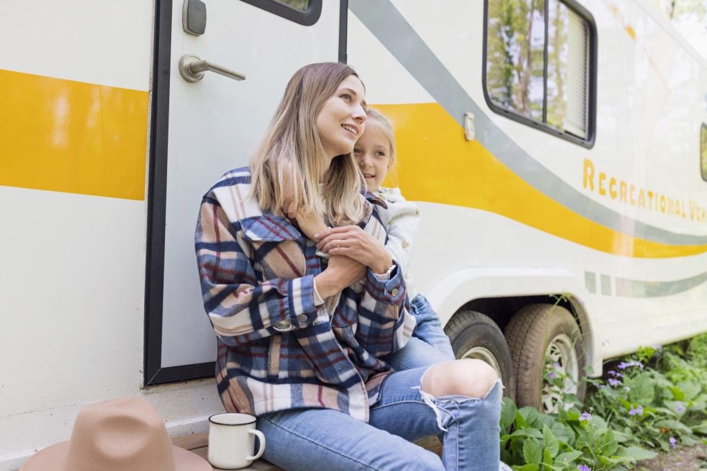 Mom and daughter posing in front of motorhome.