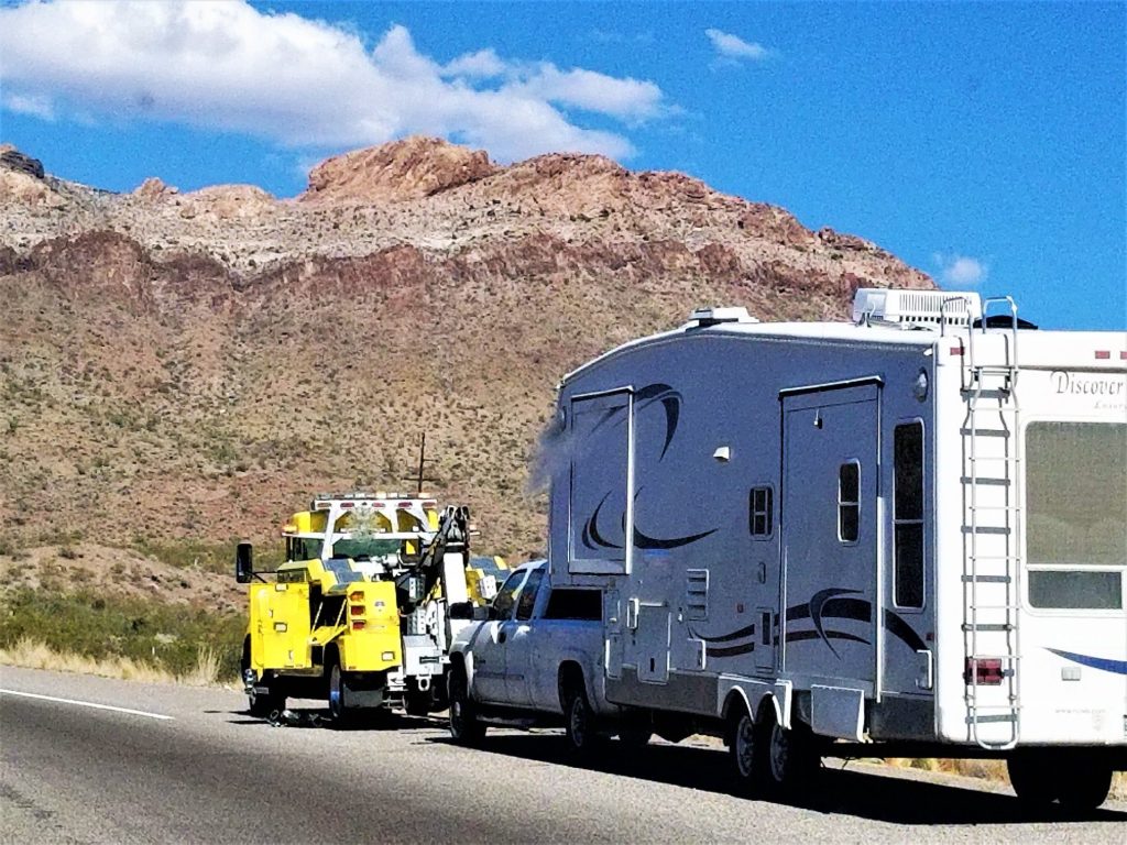 RV being towed by roadside assistance.