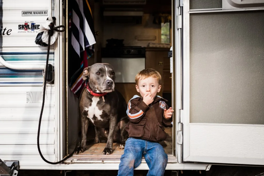 Little boy and dog sitting on RV stais.