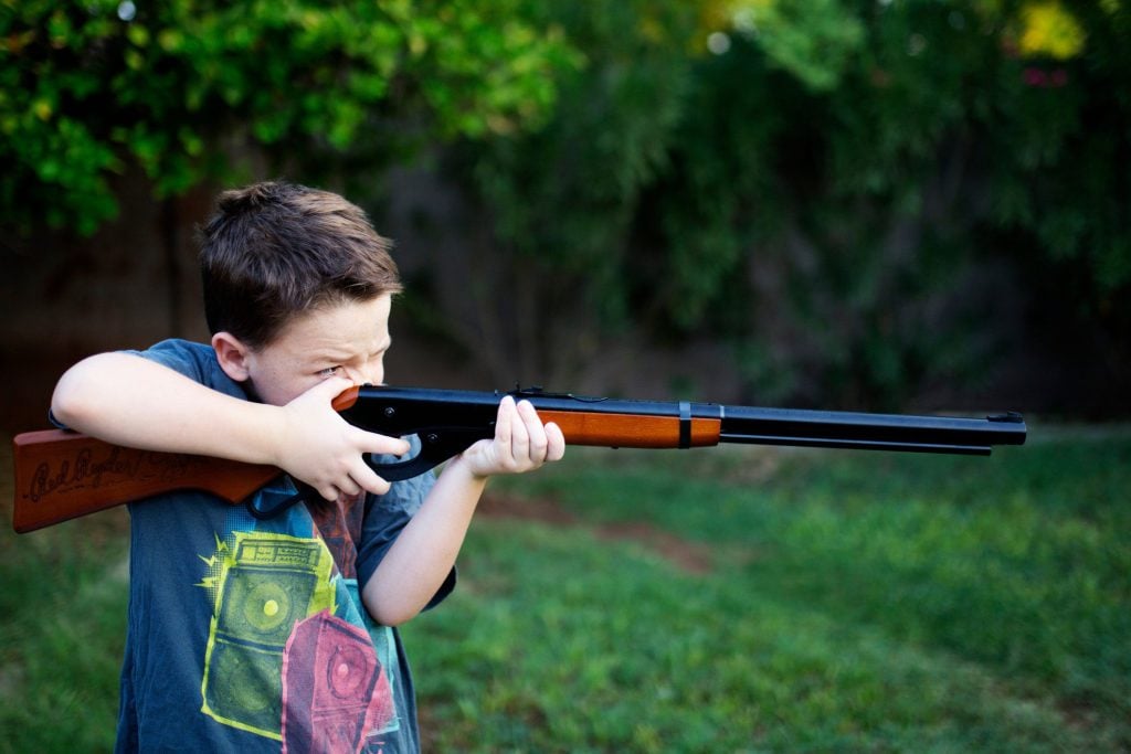 Boy shooting BB gun.