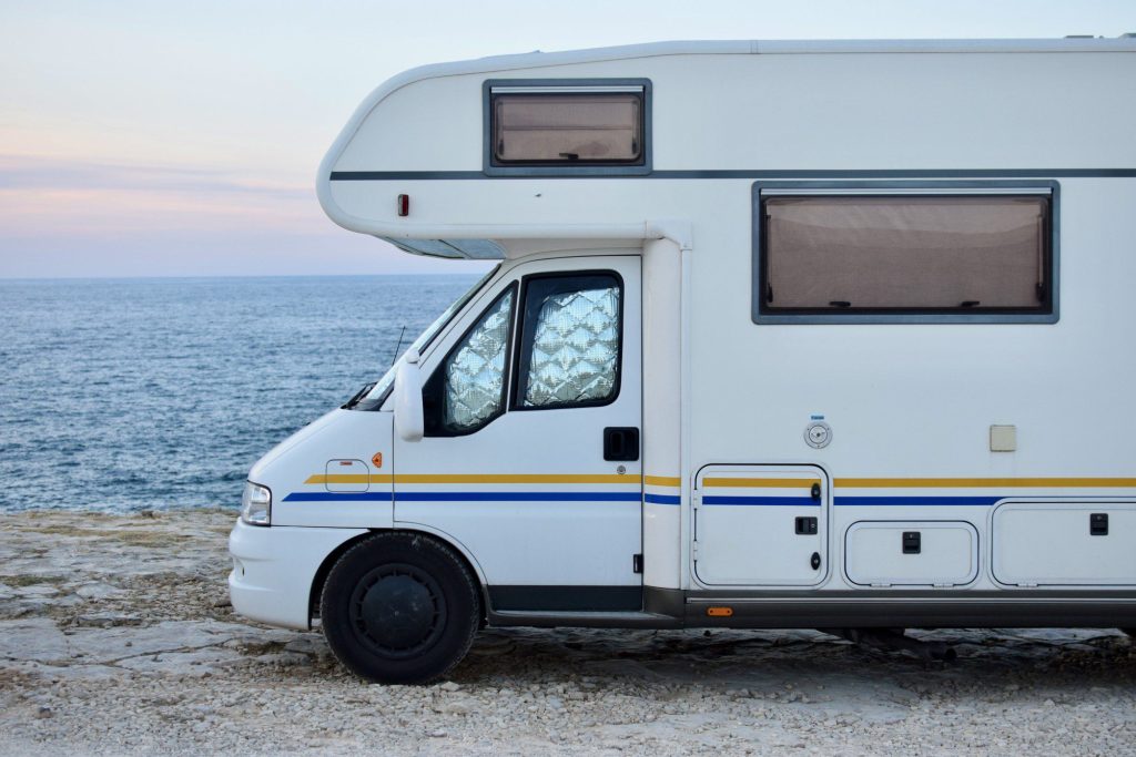 Small motorhome parked along ocean.
