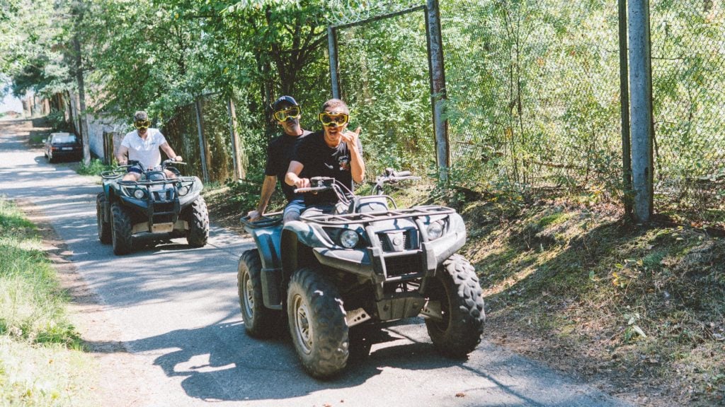 Friends driving ATVs on road together
