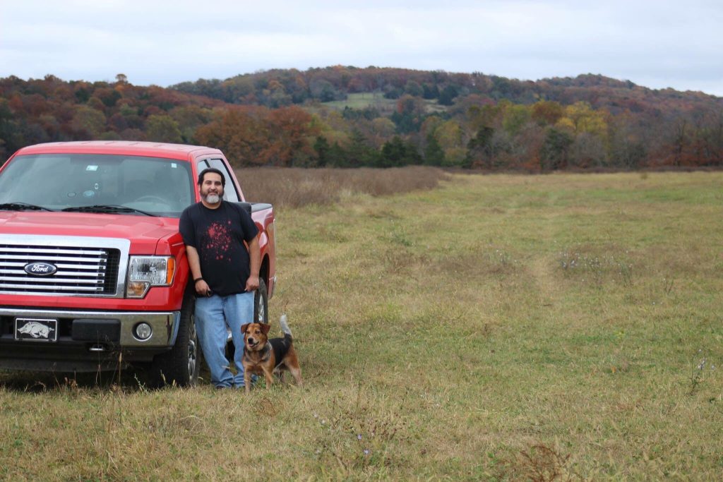 Man standing with dog in front of his Ford truck