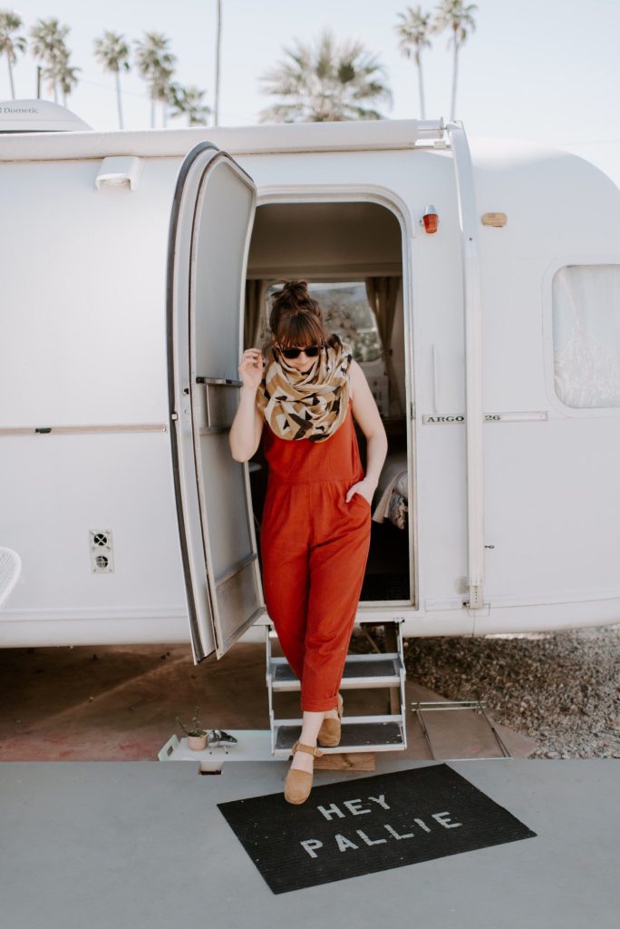 Woman posing in front of airstream.