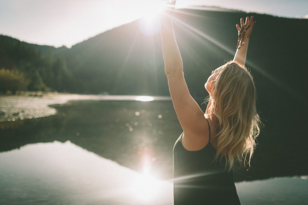 Woman doing yoga next to a lake.