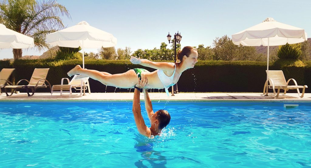 Two people doing Dirty Dancing lift in pool.