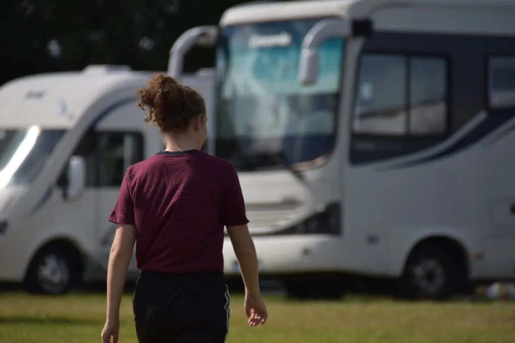 Woman walking in front of Class A RV.