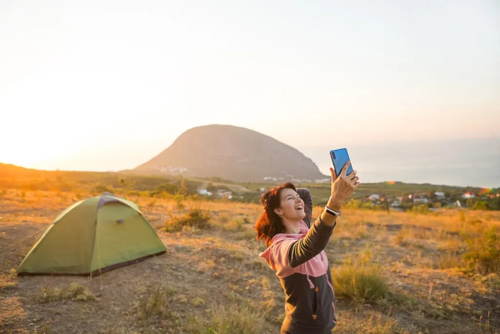 Woman facetiming while camping.
