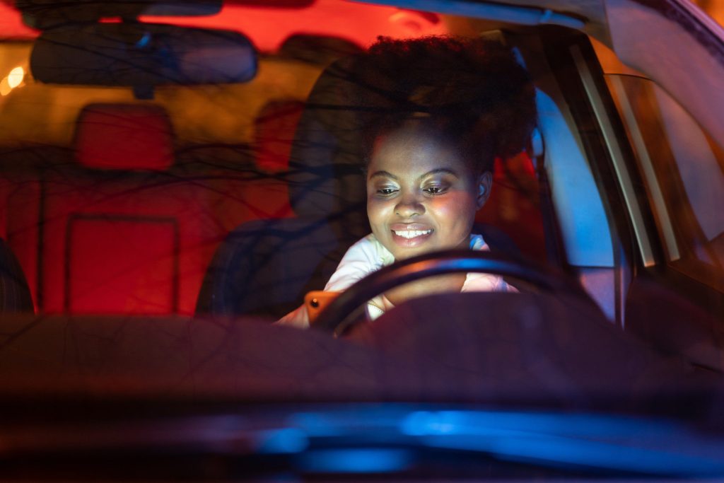 Woman on phone driving at night.