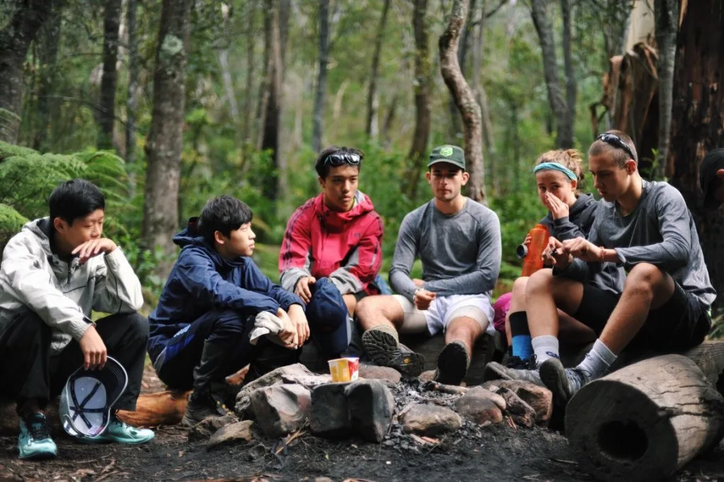 Friends sitting around campfire