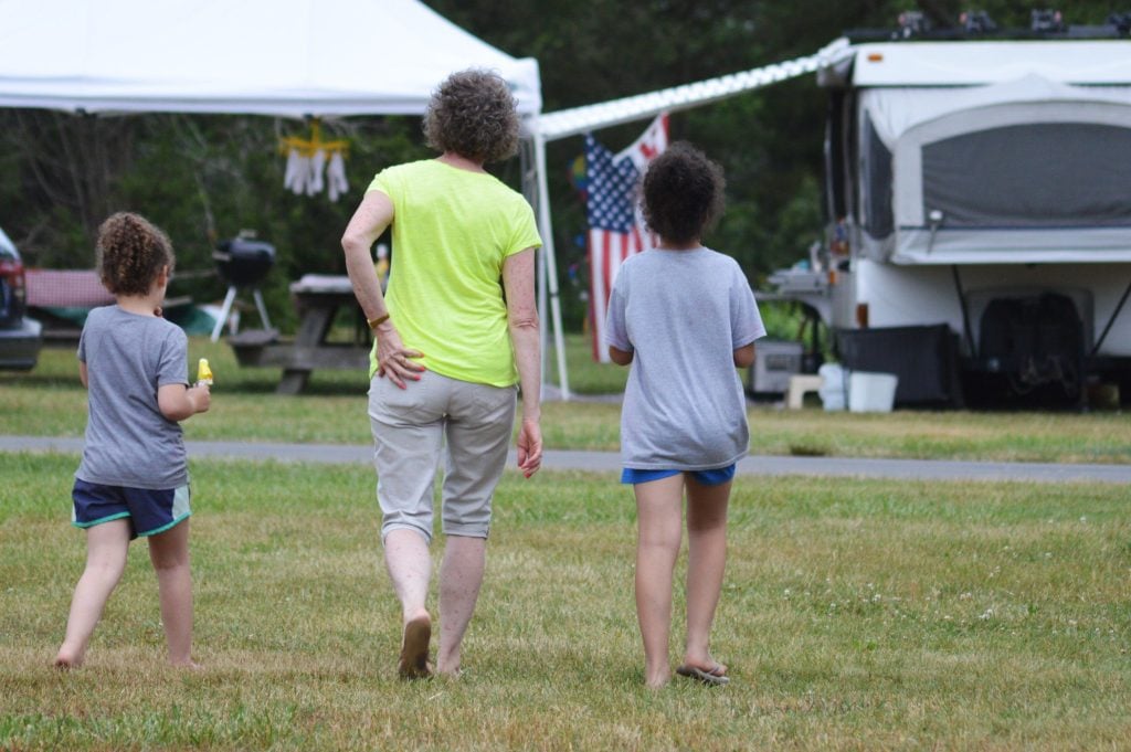 Mom and two daughters walking through other peoples RV campsite. 