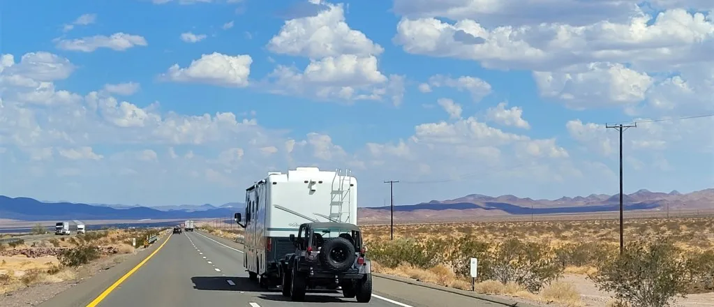 RV towing jeep down road