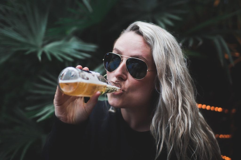 Woman drinking a bottle of beer.