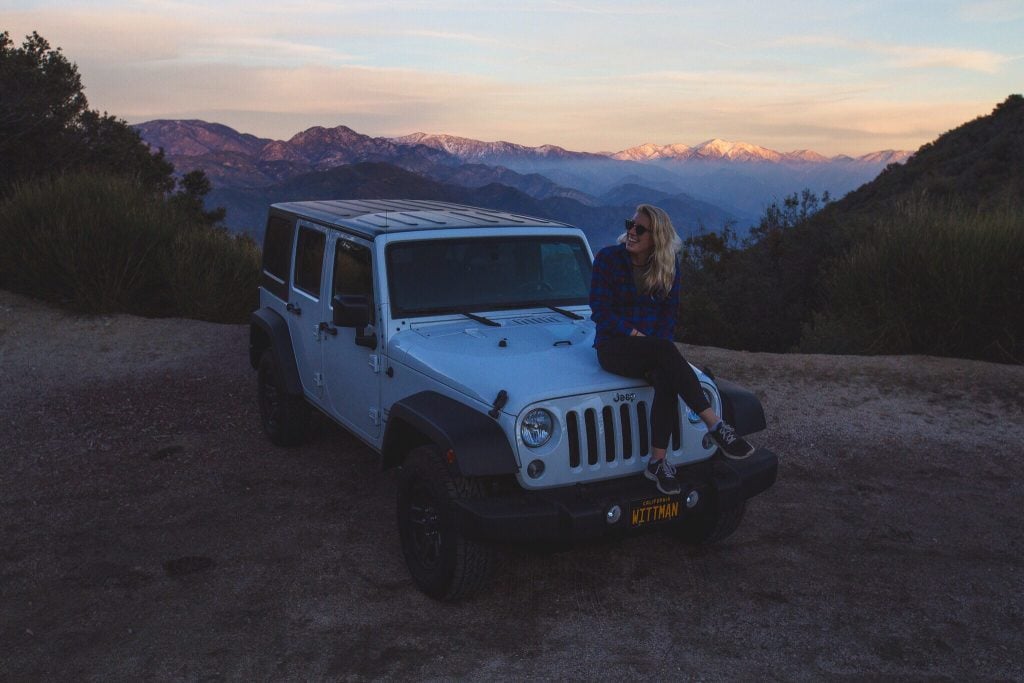 Woman sitting on top of Jeep Wrangler